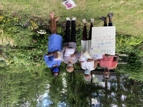 Homemade masks and sign being held by members of the Princeton Sankofa Stitchers Modern Quilt Guild